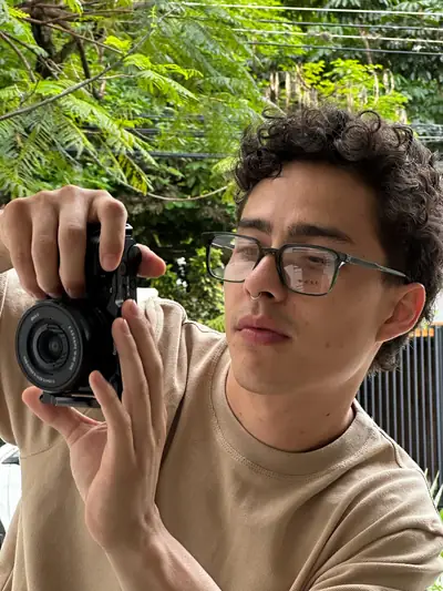 Sacando una foto con la cámara, polera beige UEBOS entre plantas